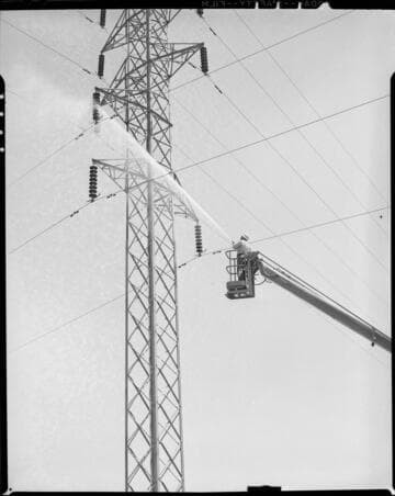 Washing insulators on double circuit tower with high pressure water gun from raised bucket