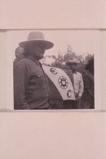 Official stamp of exploration of middle fork of 73. Buck Whitehat and Tom Daly hold the flag
