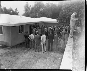 Ceremony in back yard of Millionth Meter home with family, large crowd of guests, photographers, and cinematographers