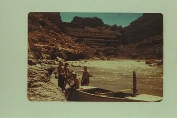 Frost party on the San Juan. Second trip of 1947. Left to right: Sam Stone; Frank E. Frost (boatman); Claude Lortz is sitting on boat; Robert L. Gates (boatman). Just below Government Rapid after running it