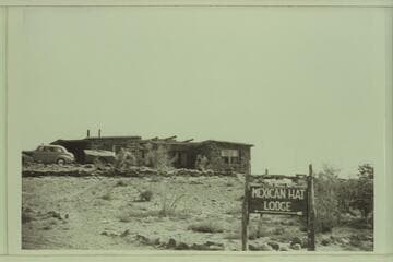 Mexican Hat Lodge. A model of one of Norman Nevills' cataract boats is on top of the sign. Don Wimpress's 8-ft. pram is seen on top of the trailer in front of the Lodge