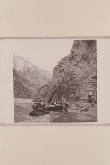 Camp at right bank of river below mouth of Supai Creek. Ballard washes dishes at edge of river, Joe polishes dishes as he sits on boat, Rod at left, works on motors and Bob picks up and packs the food