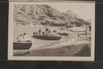 Camp below Temple Butte, Grand Canyon, Mile 66. Rod Sanderson and Dock Marston are in the "Rattlesnake", Garth Marston stands near the boat and Joe Desloge walks on the beach